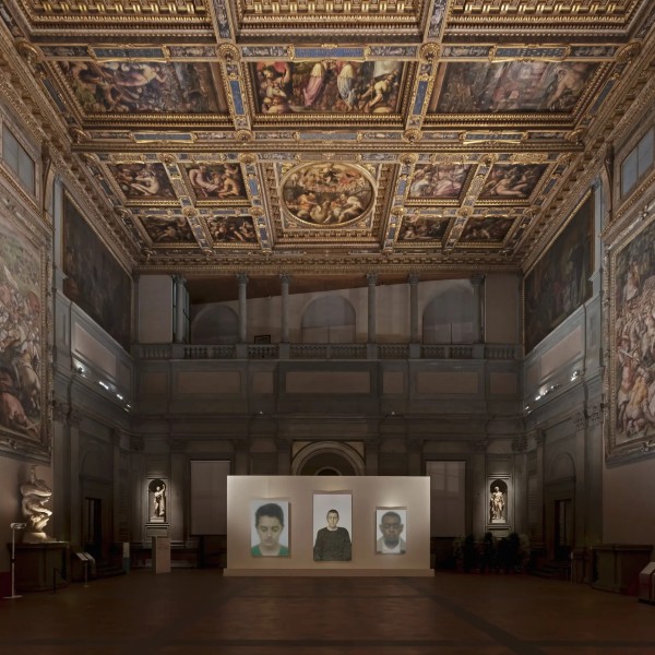 Three portraits by Y.Z. Kami, from left at rear — “Marwin” (2013-14); “Untitled (Woman in Green Sweater)” (2006); and “Untitled” (2011) — surrounded by 16th-century frescoes by Giorgio Vasari, at the Palazzo Vecchio in Florence, Italy. Picture from New York Times